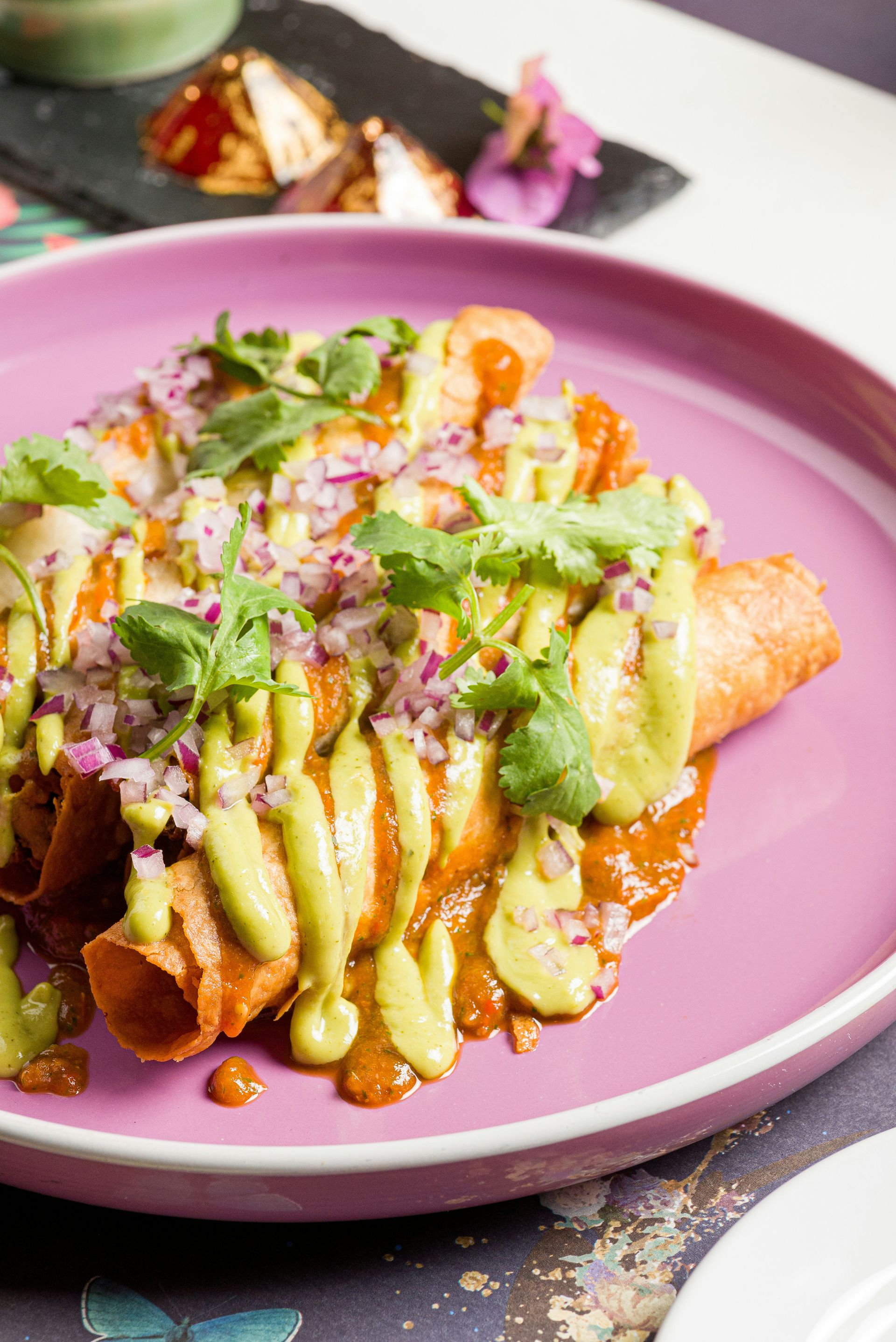 a pink plate topped with food on top of a table